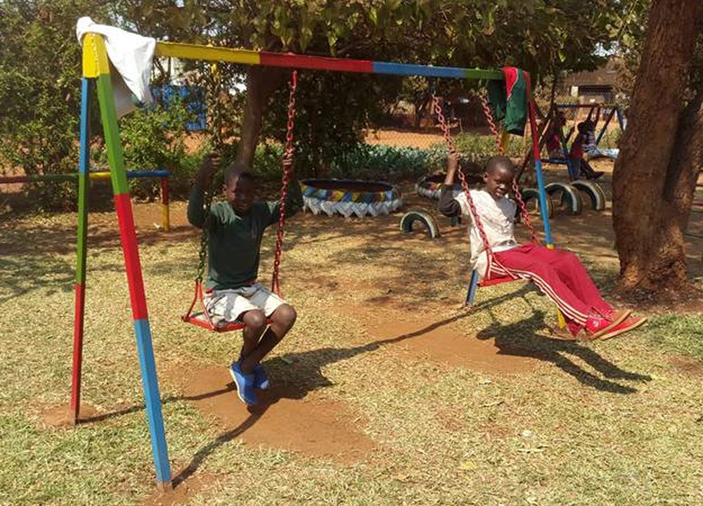 Children on the swings at the Mumvuri Project community centre